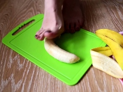 Dominant young babe crushing a banana with her lovely feet